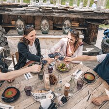 Two couples toast with a glass of red wine.  | © Gabriel Perren