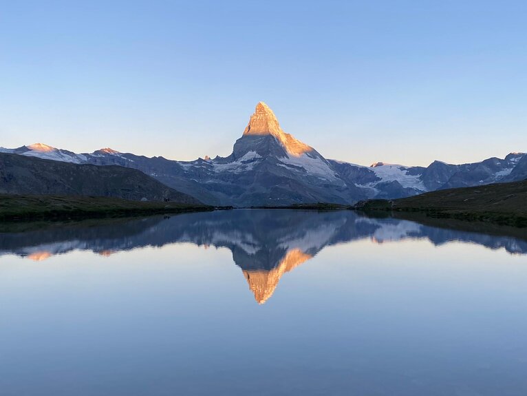 Classic sunrise with reflection of the Matterhorn with shining peak in the clear Stelli Lake | © Zermatt Bergbahnen