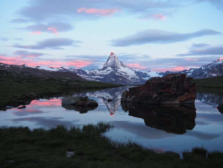 Sunrise at Stellisee - The Matterhorn reflected in Stellisee with snow-covered summit, clouds and morning atmosphere | © Zermatt Bergbahnen