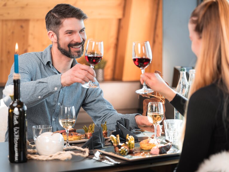 Ein Paar stosst beim Sunset Dinner im Matterhorn Glacier Paradise mit einem Glas Wein an.  | © Basic Home Production