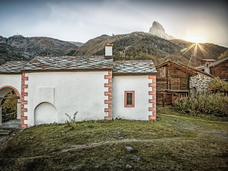 Die Kapelle Blatten in den letzten Sonnenstrahelen, die hinter dem Matterhorn untergehen | © Andrea Soltemann