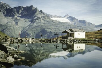 Die sich im Schwarzsee spiegelnde Kapelle Maria zum Schnee, eingebettet in die Zermatter Bergwelt | © Mateusz Bocian