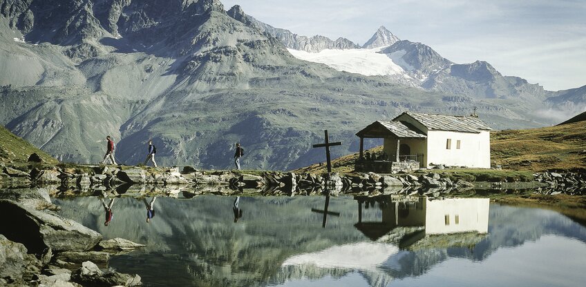 Die sich im Schwarzsee spiegelnde Kapelle Maria zum Schnee, eingebettet in die Zermatter Bergwelt | © Mateusz Bocian