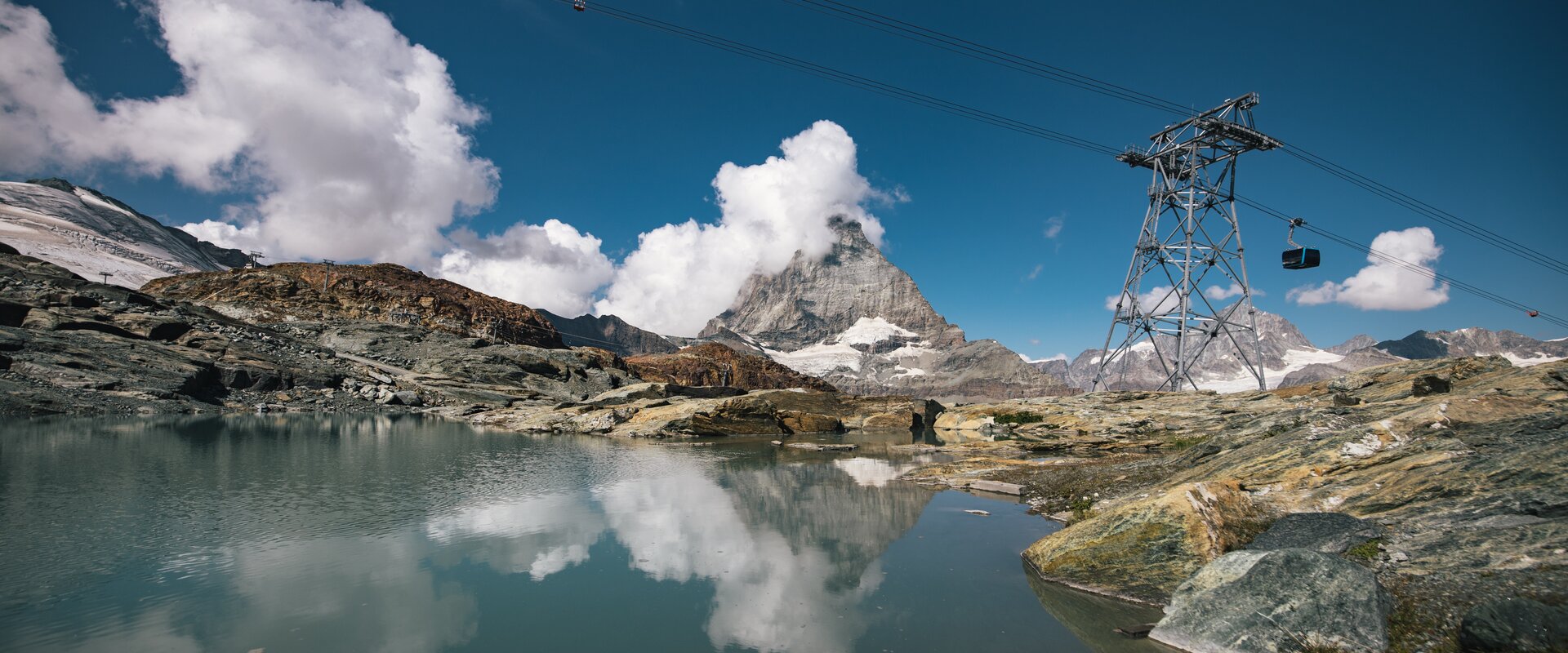 Der Theodulsee auf Trockener Steg, das Matterhorn und die Gondeln der Glacier Ride | © Mitch Pitmann