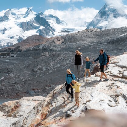 Famille descendant des rochers, en arrière-plan, Breithorn et Dufourspitze | © basic_home