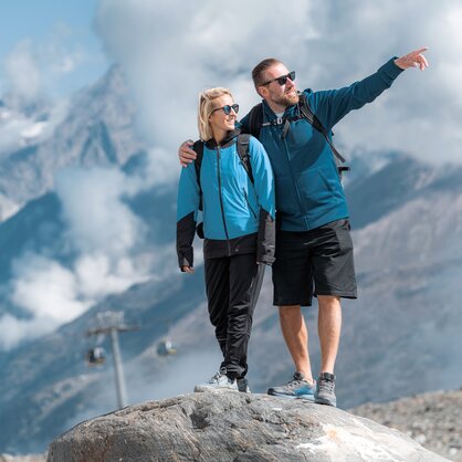 Couple debout sur un rocher, avec le MEX et les montagnes de Zermatt en arrière-plan | © basic_home