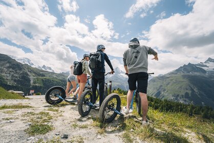 A group enjoys the view of Sunnegga before venturing downhill on the kickbike.  | © Gabriel Perren