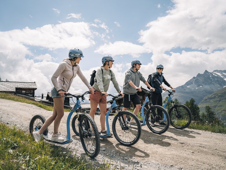 A group of adventurous kickbikers takes a short break at the height of Tufteren.  | © Gabriel Perren