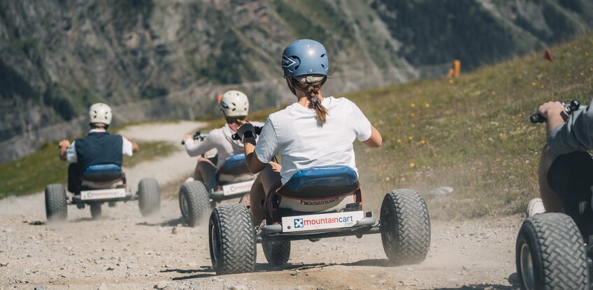 Eine Gruppe düst mit den Mountaincarts den Berg hinunter. | © Gabriel Perren
