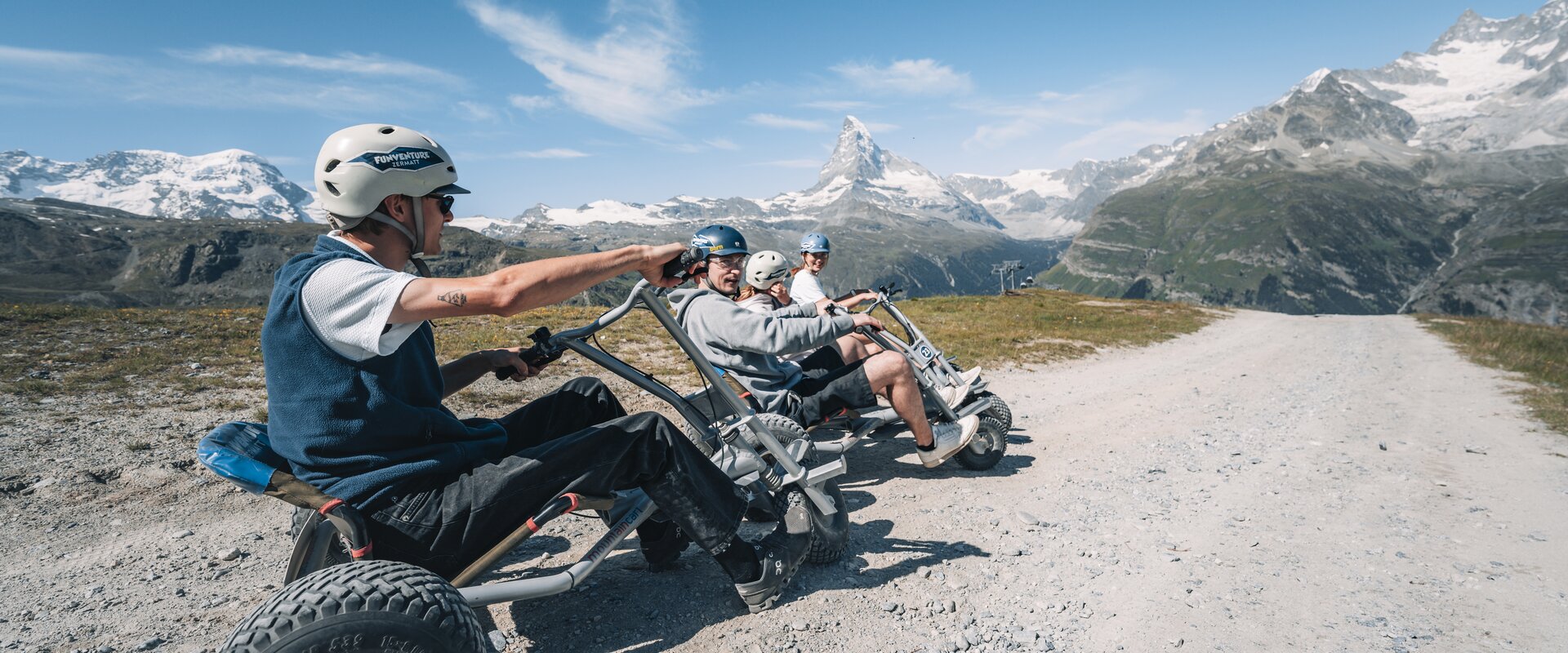 Un gruppo si siede pronto a partire con i loro mountaincarts con il tempo migliore e la vista del Cervino.  | © Gabriel Perren