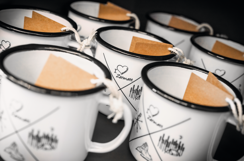 Weisse Souvenirtassen, die in den Shops des Matterhorn Paradise gekauft werden können.  | © Zermatt Bergbahnen